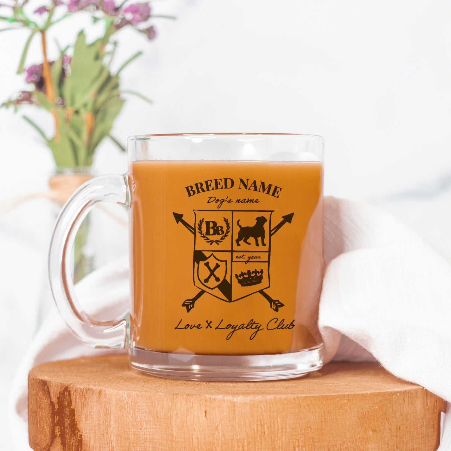 Clear mug with a design on a wooden block with a white background